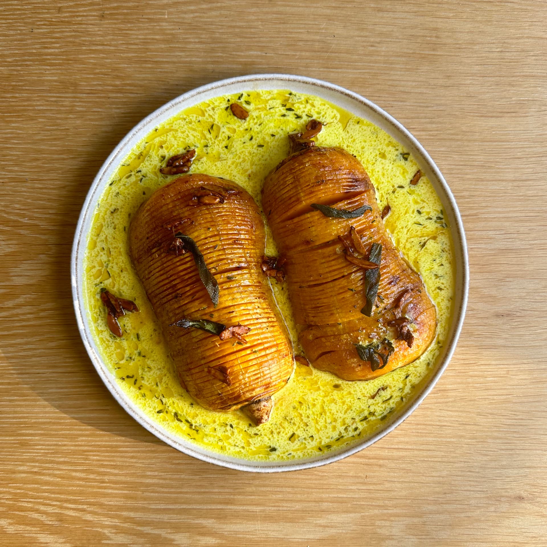 Overhead of hasselbacked butternut squash on plate with creamed sauce